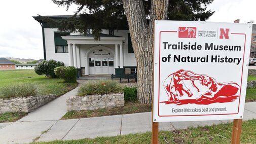Exterior of Trailside Museum with large sign including red battling mammoths graphic. 