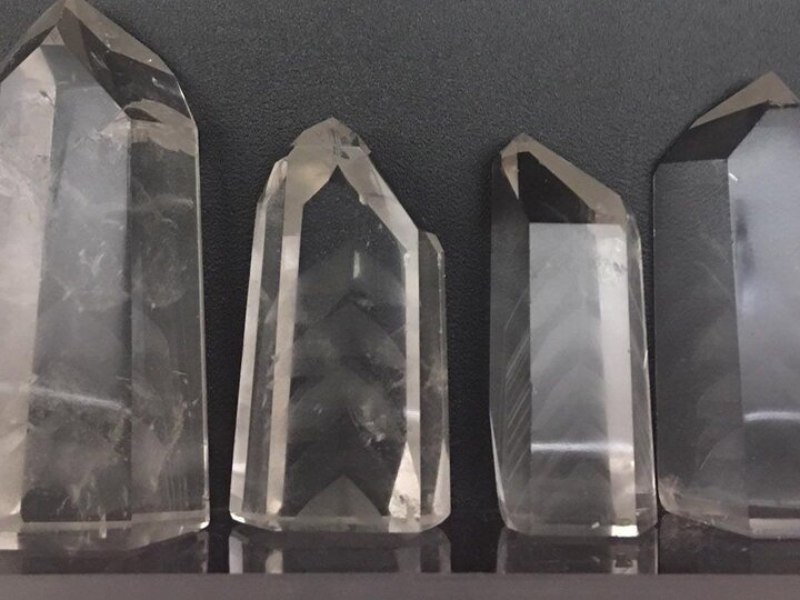 Four large clear crystals on a dark background.